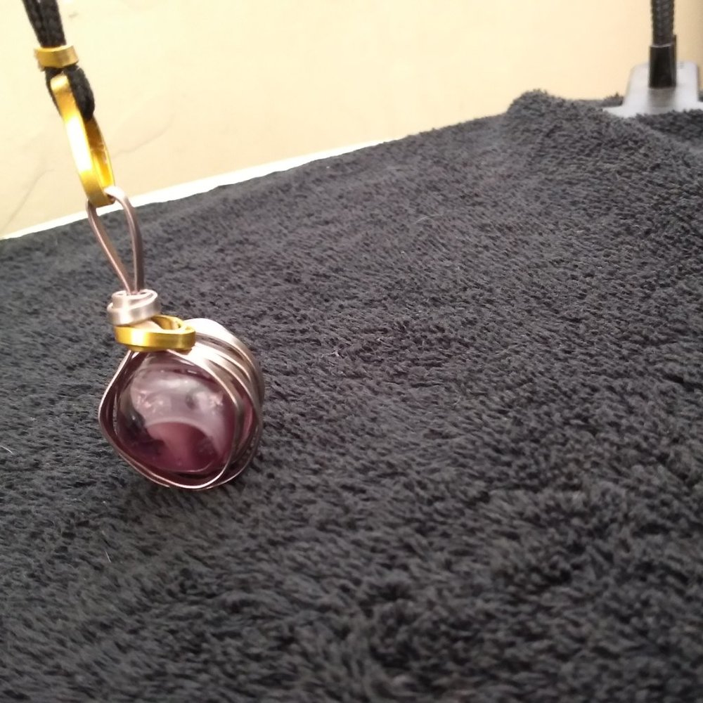 Spinning purple marble necklace in gold and silver tone swirled cage rope